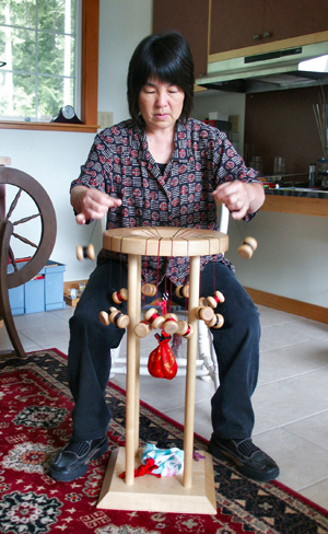 Jan Buday of Karei working on a marudai with bobbins flying