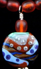 Necklace of silver beads and findings, amber beads, Moretti glass flameworked focal bead.